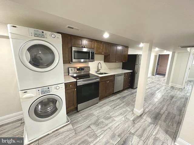75 New York Ave NW, Washington, DC 20001 - kitchen featuring appliances with stainless steel finishes, stacked washer and clothes dryer, light countertops, and dark brown cabinetry