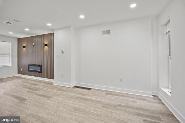 239 Rubicam St, Philadelphia, PA 19120 - unfurnished living room featuring heating unit, recessed lighting, light wood-style flooring, and a large fireplace
