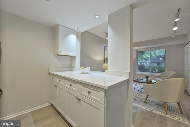 1814 Ivy Oak Sq, Reston, VA 20190 - kitchen featuring light wood finished floors, white cabinetry, rail lighting, light stone counters, and recessed lighting