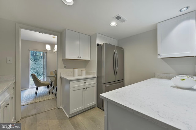 1814 Ivy Oak Sq, Reston, VA 20190 - kitchen with freestanding refrigerator, light wood-style floors, white cabinets, recessed lighting, and light stone counters