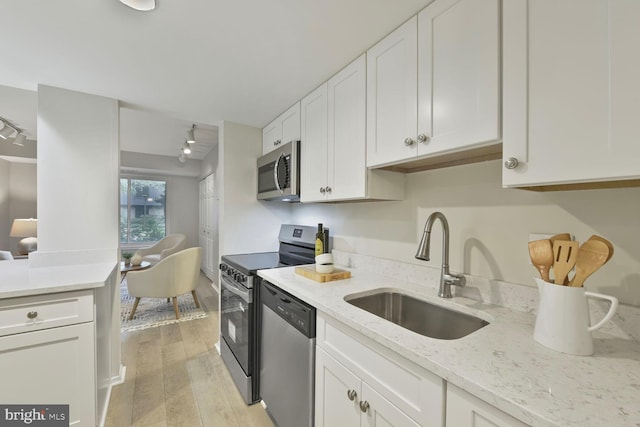 1814 Ivy Oak Sq, Reston, VA 20190 - kitchen with appliances with stainless steel finishes, white cabinets, light wood-type flooring, and light stone counters
