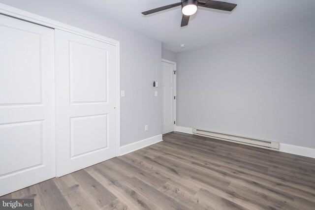 511 E Green St, Oakland, MD 21550 - unfurnished bedroom with baseboard heating, wood finished floors, a closet, and a ceiling fan