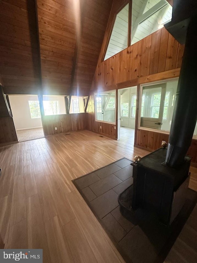 556 Trapper Ridge Ln, Hedgesville, WV 25427 - living area with a wood stove, a wooden ceiling with exposed beams, healthy amount of natural light, wood finished floors, and wood walls