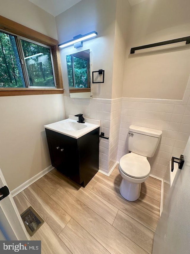 556 Trapper Ridge Ln, Hedgesville, WV 25427 - half bathroom with tile walls, vanity, wood finished floors, wainscoting, and plenty of natural light