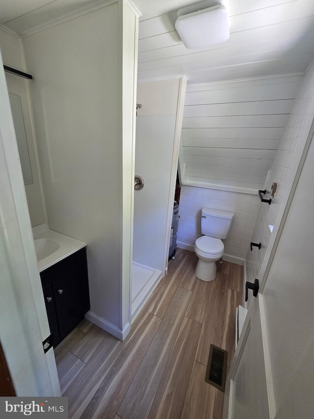 556 Trapper Ridge Ln, Hedgesville, WV 25427 - bathroom featuring wood finished floors, vanity, crown molding, and tile walls