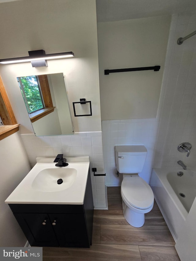556 Trapper Ridge Ln, Hedgesville, WV 25427 - bathroom with tile walls, wood finished floors, vanity, shower / tub combination, and wainscoting