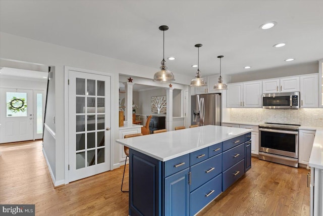 5304 Braddock Ridge Dr, Centreville, VA 20120 - kitchen with appliances with stainless steel finishes, blue cabinetry, white cabinetry, light countertops, and tasteful backsplash