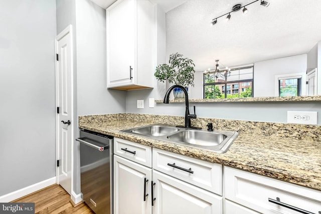 1111 25th St NW Unit 521, Washington, DC 20037 - kitchen with light wood finished floors, stainless steel dishwasher, a chandelier, and white cabinets