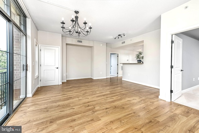1111 25th St NW Unit 521, Washington, DC 20037 - unfurnished living room featuring a chandelier, light wood-style floors, and rail lighting