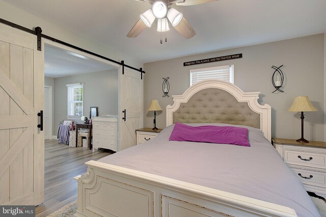 1326 Balsam St, Saint Leonard, MD 20685 - bedroom featuring a barn door, light wood-type flooring, and ceiling fan