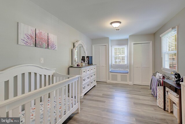 1326 Balsam St, Saint Leonard, MD 20685 - bedroom with light wood finished floors, multiple closets, and a nursery area