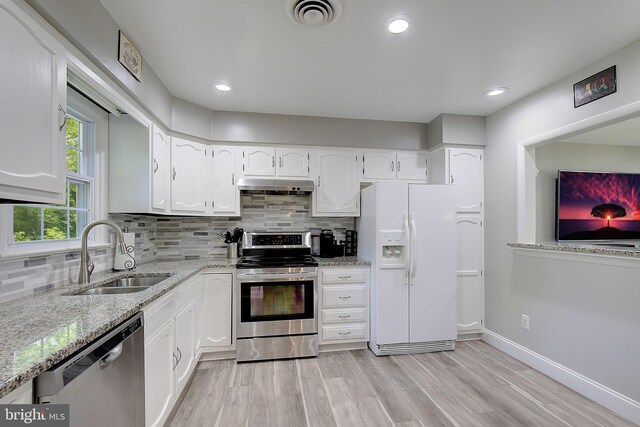 1326 Balsam St, Saint Leonard, MD 20685 - kitchen featuring stainless steel appliances, under cabinet range hood, light stone counters, white cabinetry, and light wood finished floors