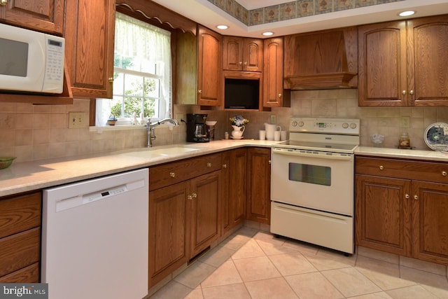 401 Antietam Rd, Reading, PA 19606 - kitchen featuring white appliances, premium range hood, brown cabinetry, and light countertops