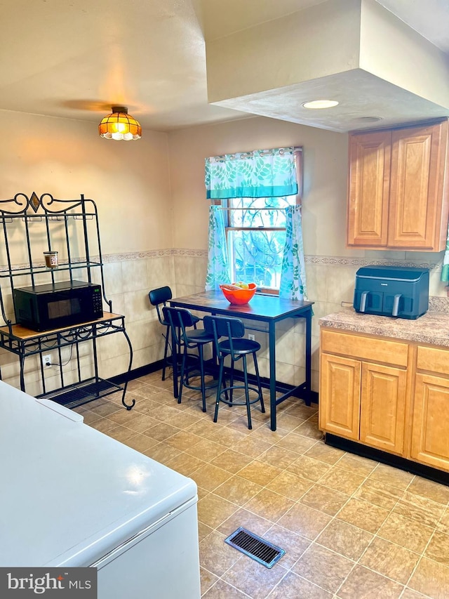 2817 Boyd St, Pennsauken, NJ 08110 - kitchen featuring tile walls, black microwave, wainscoting, and light countertops