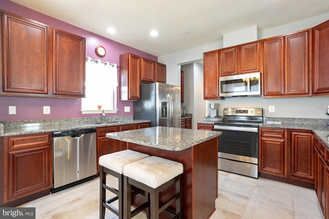 1712 Renaissance Dr, Baltimore, MD 21221 - kitchen featuring appliances with stainless steel finishes, a kitchen island, light stone counters, a kitchen bar, and recessed lighting