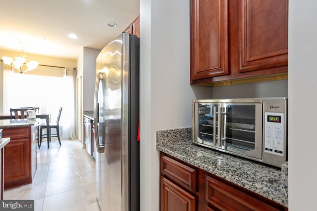 1712 Renaissance Dr, Baltimore, MD 21221 - kitchen with freestanding refrigerator, a chandelier, light stone countertops, light tile patterned flooring, and recessed lighting