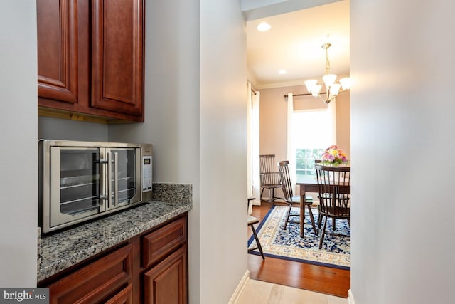 1712 Renaissance Dr, Baltimore, MD 21221 - kitchen with light stone countertops, a chandelier, wood finished floors, decorative light fixtures, and recessed lighting