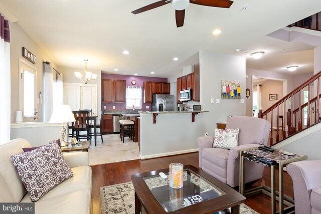 1712 Renaissance Dr, Baltimore, MD 21221 - living area featuring ceiling fan, a chandelier, wood finished floors, stairs, and recessed lighting