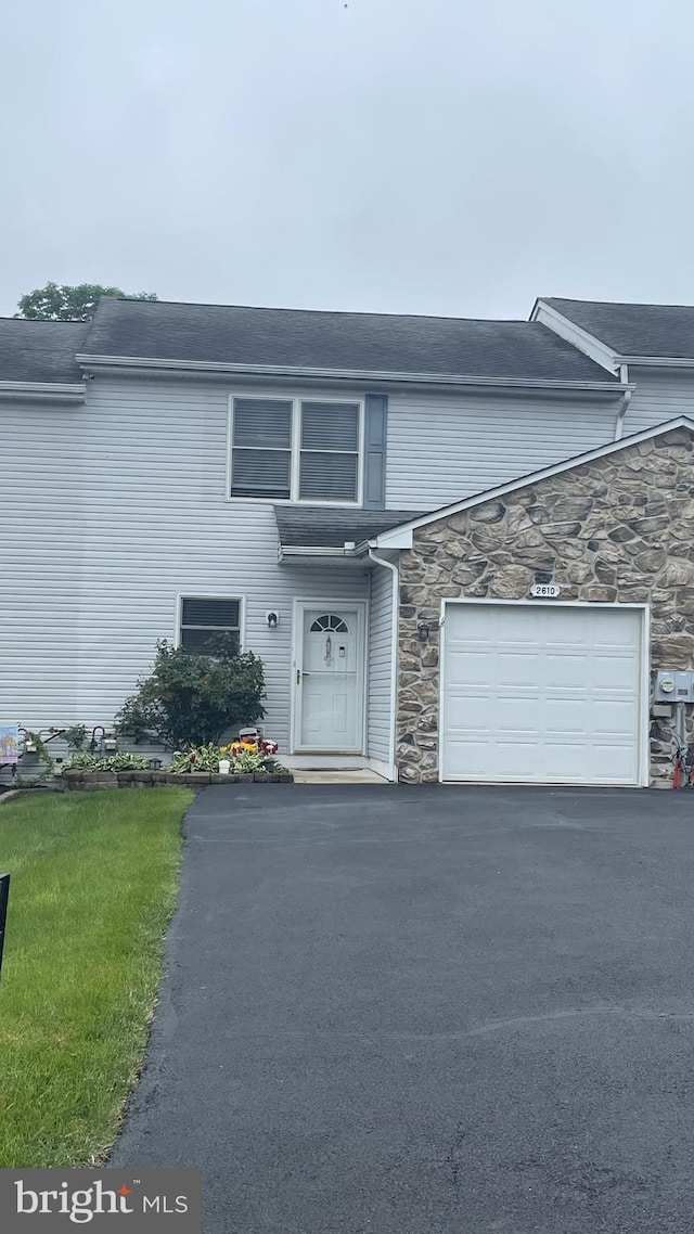2610 Daniels Ln, Quakertown, PA 18951 - view of front of house with stone siding, driveway, a front yard, and a garage
