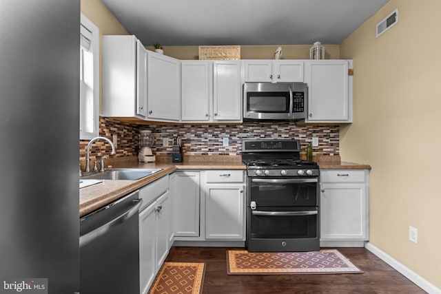 2610 Daniels Ln, Quakertown, PA 18951 - kitchen with stainless steel appliances, dark wood-style flooring, tasteful backsplash, and white cabinets
