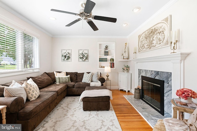 143 Moore Ave, Barrington, NJ 08007 - living area with wood finished floors, a premium fireplace, ceiling fan, crown molding, and built in shelves