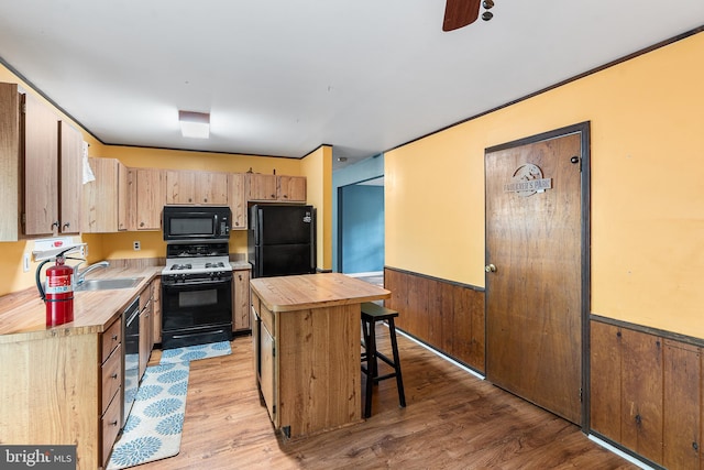 71 Winfield Rd, Sicklerville, NJ 08081 - kitchen featuring black appliances, wood counters, a wainscoted wall, a kitchen island, and light wood-type flooring