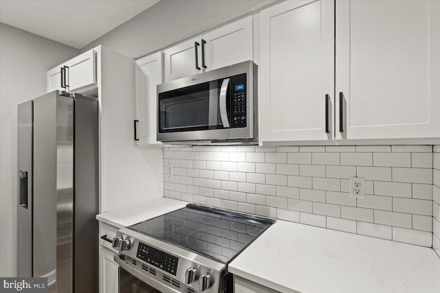 1801 Calvert St NW Unit 204, Washington, DC 20009 - kitchen featuring appliances with stainless steel finishes, light countertops, white cabinetry, and decorative backsplash