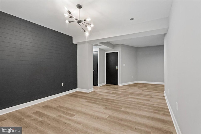 1801 Calvert St NW Unit 204, Washington, DC 20009 - empty room featuring light wood-type flooring, an accent wall, and a chandelier