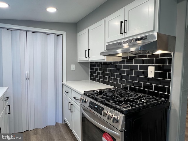 6309 61st Pl, Riverdale, MD 20737 - kitchen with gas stove, wood finished floors, under cabinet range hood, white cabinets, and tasteful backsplash