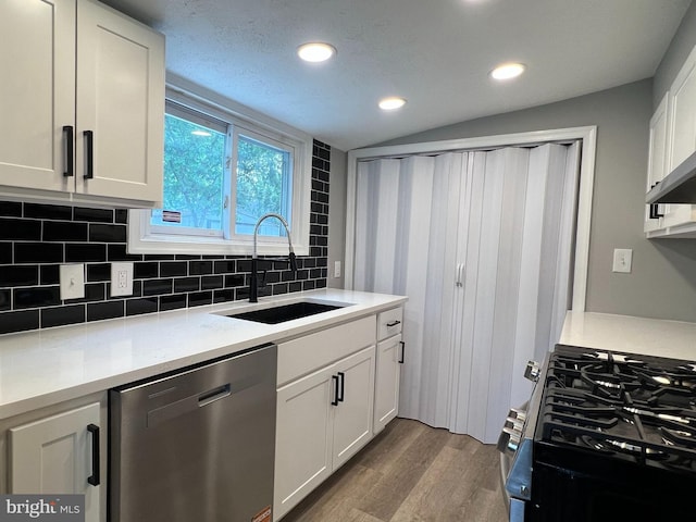 6309 61st Pl, Riverdale, MD 20737 - kitchen featuring appliances with stainless steel finishes, wood finished floors, decorative backsplash, white cabinetry, and recessed lighting