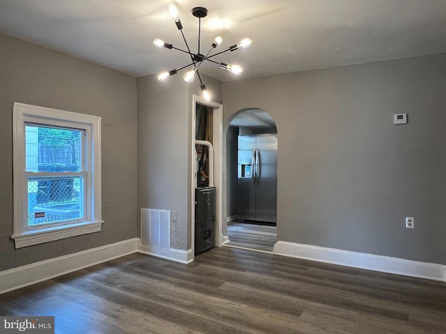 6309 61st Pl, Riverdale, MD 20737 - unfurnished room featuring arched walkways, a chandelier, and dark wood-style flooring