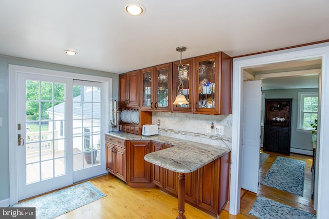 175 Pullen Station Rd, Quakertown, PA 18951 - kitchen with brown cabinetry, light stone counters, light wood-style flooring, a baseboard heating unit, and glass insert cabinets