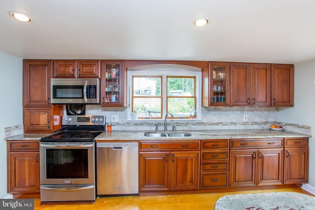 175 Pullen Station Rd, Quakertown, PA 18951 - kitchen with stainless steel appliances, tasteful backsplash, light stone counters, glass insert cabinets, and brown cabinets