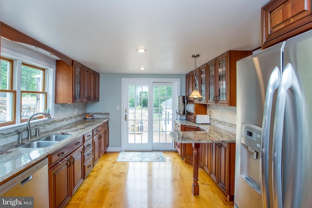 175 Pullen Station Rd, Quakertown, PA 18951 - kitchen featuring stainless steel appliances, brown cabinetry, glass insert cabinets, light wood-style flooring, and backsplash