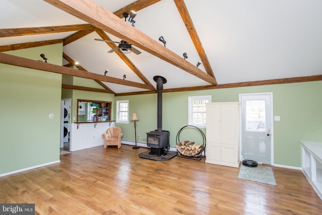 175 Pullen Station Rd, Quakertown, PA 18951 - unfurnished living room featuring stacked washing machine and dryer, a wood stove, beam ceiling, baseboard heating, and high vaulted ceiling