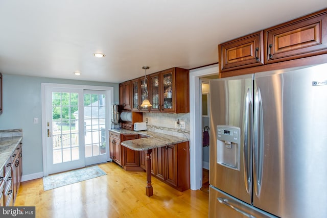 175 Pullen Station Rd, Quakertown, PA 18951 - kitchen with stainless steel refrigerator with ice dispenser, brown cabinetry, light wood-style floors, glass insert cabinets, and light stone countertops