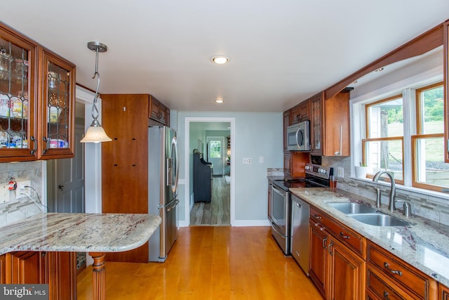 175 Pullen Station Rd, Quakertown, PA 18951 - kitchen with appliances with stainless steel finishes, tasteful backsplash, light wood-style flooring, light stone counters, and brown cabinets