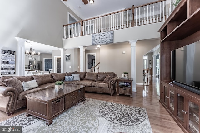 12655 Arthur Graves Jr Ct, Bristow, VA 20136 - living area featuring decorative columns, light wood-style floors, a towering ceiling, stairway, and ceiling fan