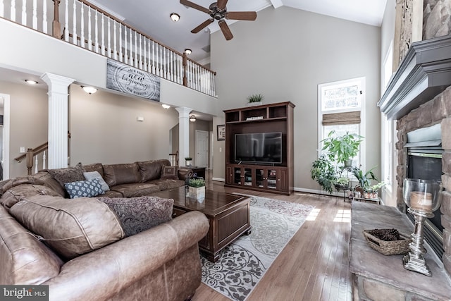 12655 Arthur Graves Jr Ct, Bristow, VA 20136 - living room featuring decorative columns, high vaulted ceiling, ceiling fan, wood finished floors, and a stone fireplace