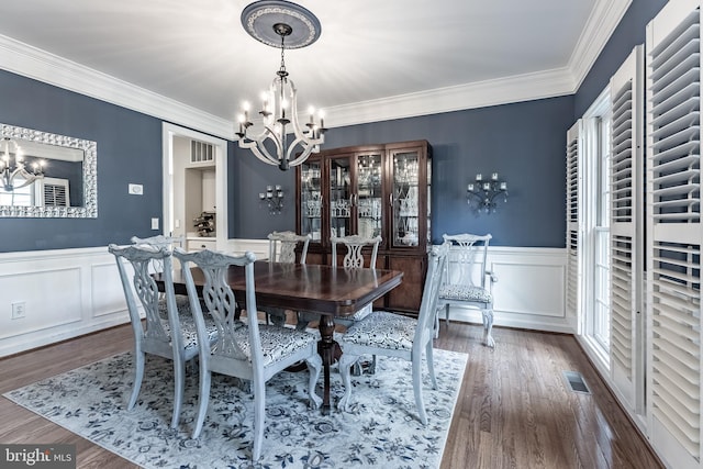 12655 Arthur Graves Jr Ct, Bristow, VA 20136 - dining space featuring a chandelier, dark wood finished floors, ornamental molding, wainscoting, and a decorative wall
