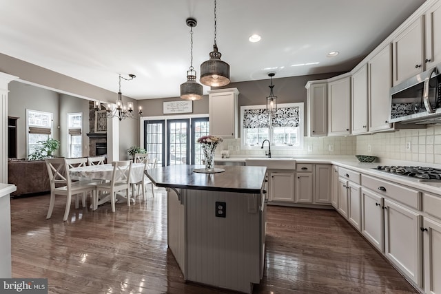 12655 Arthur Graves Jr Ct, Bristow, VA 20136 - kitchen with appliances with stainless steel finishes, decorative backsplash, dark wood-style floors, a center island, and recessed lighting