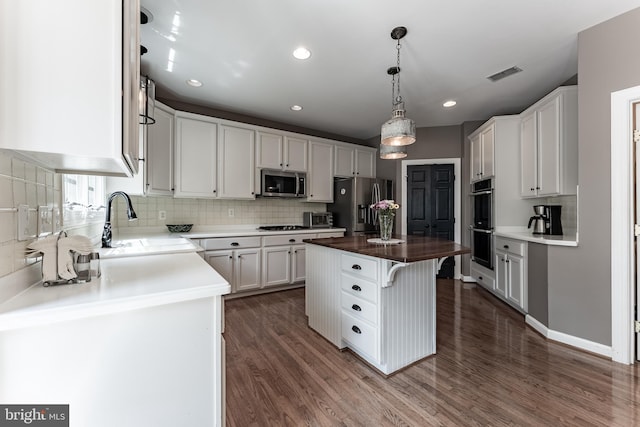 12655 Arthur Graves Jr Ct, Bristow, VA 20136 - kitchen with appliances with stainless steel finishes, decorative backsplash, dark wood-style floors, a center island, and white cabinets