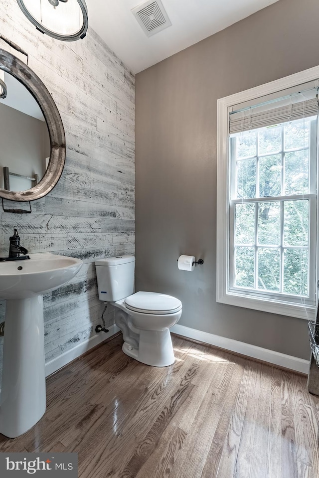 12655 Arthur Graves Jr Ct, Bristow, VA 20136 - half bathroom with an accent wall, wood walls, and wood finished floors