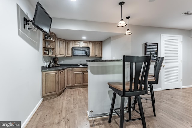 12655 Arthur Graves Jr Ct, Bristow, VA 20136 - kitchen with black microwave, light wood finished floors, open shelves, dark countertops, and pendant lighting