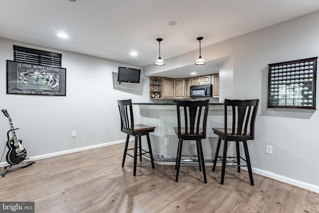 12655 Arthur Graves Jr Ct, Bristow, VA 20136 - kitchen featuring black microwave, open shelves, light wood finished floors, a breakfast bar area, and recessed lighting