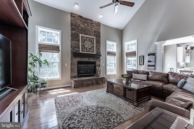 12655 Arthur Graves Jr Ct, Bristow, VA 20136 - living room with high vaulted ceiling, a stone fireplace, a ceiling fan, wood-type flooring, and a chandelier
