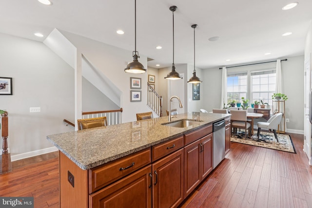 9924 Whitemoss Dr, Manassas, VA 20109 - kitchen featuring stainless steel dishwasher, dark wood-type flooring, recessed lighting, light stone counters, and an island with sink