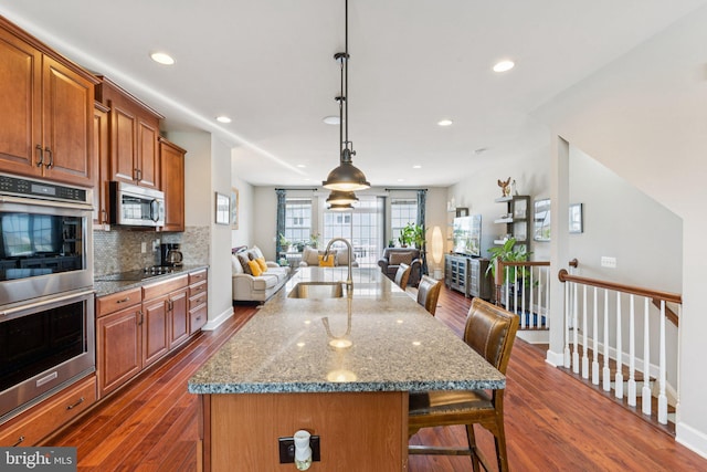 9924 Whitemoss Dr, Manassas, VA 20109 - kitchen featuring stainless steel appliances, open floor plan, a kitchen breakfast bar, dark wood-style flooring, and recessed lighting