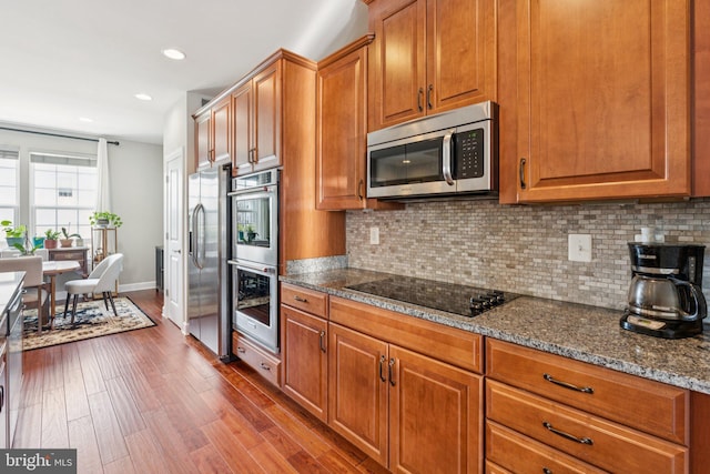 9924 Whitemoss Dr, Manassas, VA 20109 - kitchen featuring appliances with stainless steel finishes, decorative backsplash, dark wood-type flooring, brown cabinetry, and recessed lighting