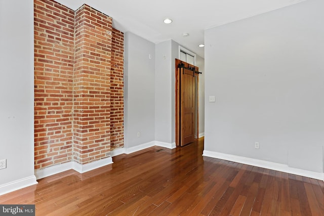 3016 Dillon St, Baltimore, MD 21224 - spare room featuring hardwood / wood-style floors, a barn door, and recessed lighting